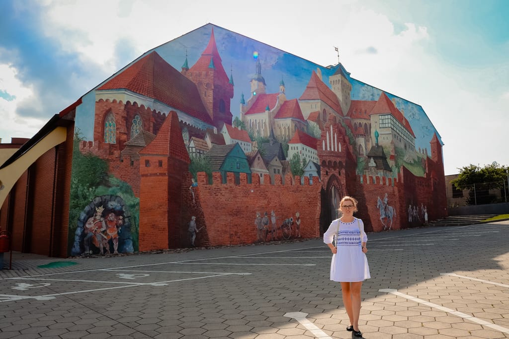 Mural na szkole - przedstawiający historyczne Pyzdry za czasów królewskiego miasta.